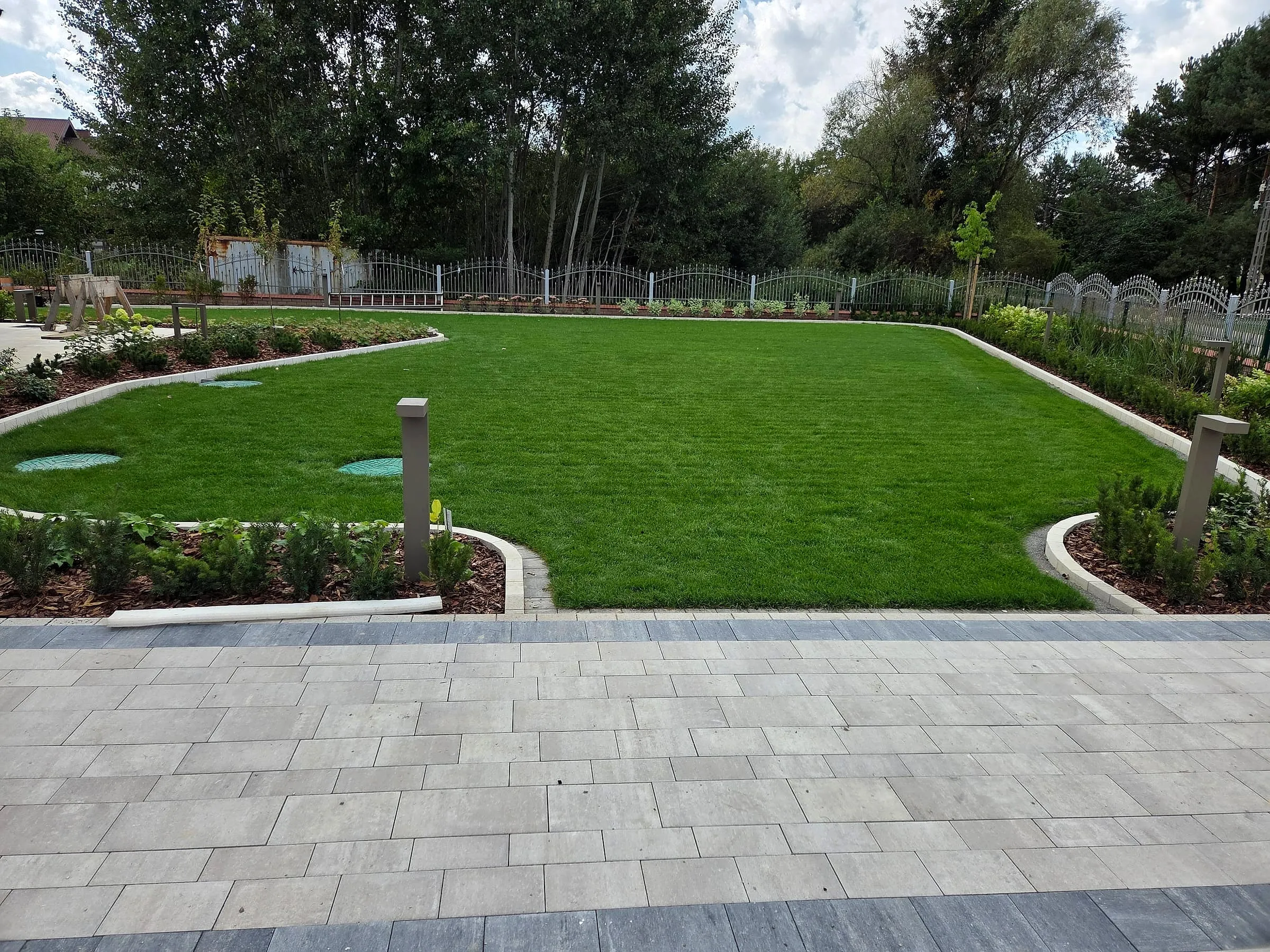 Zadbany ogród z rozległym trawnikiem zrealizowany przez Health Garden